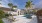 a swimming pool with palm trees and a building in the background